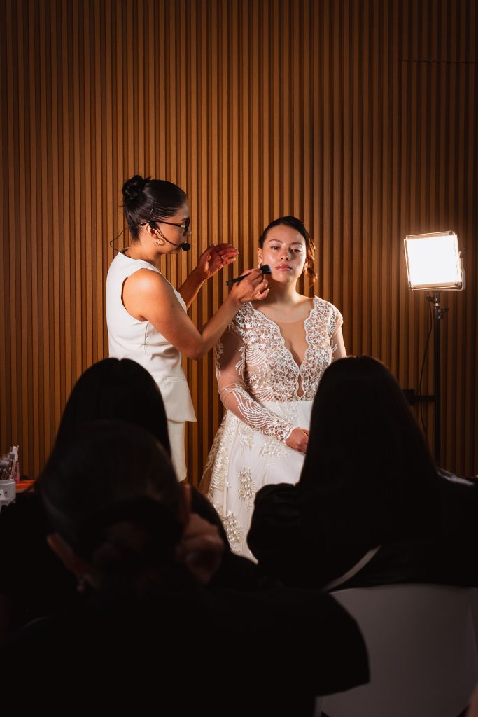 Bride receiving makeup in a dimly lit venue during a wedding in Mexico City.